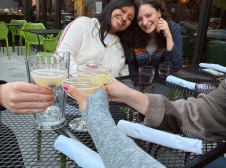 Maria and Eleanor at an outdoor restaurant. Friends toast.