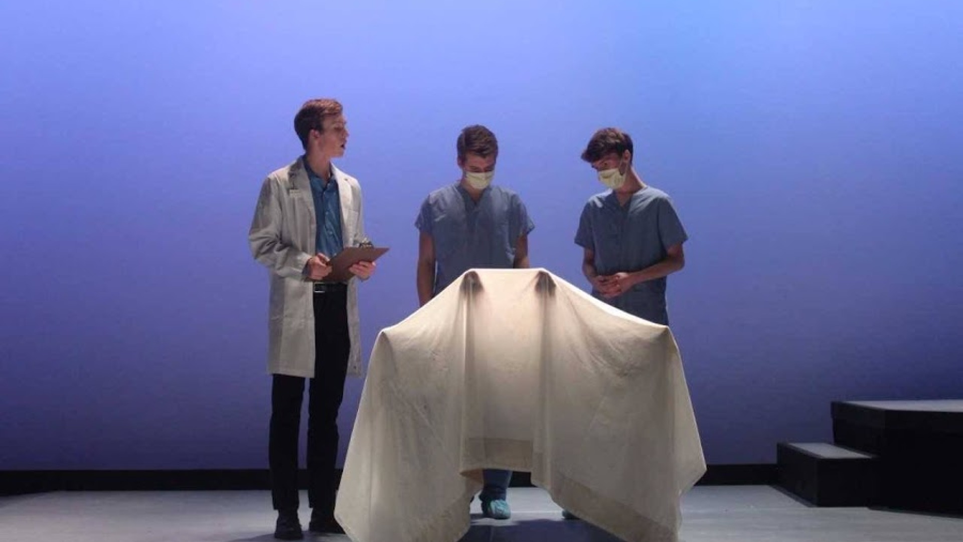 Students playing as doctors in morgue in play