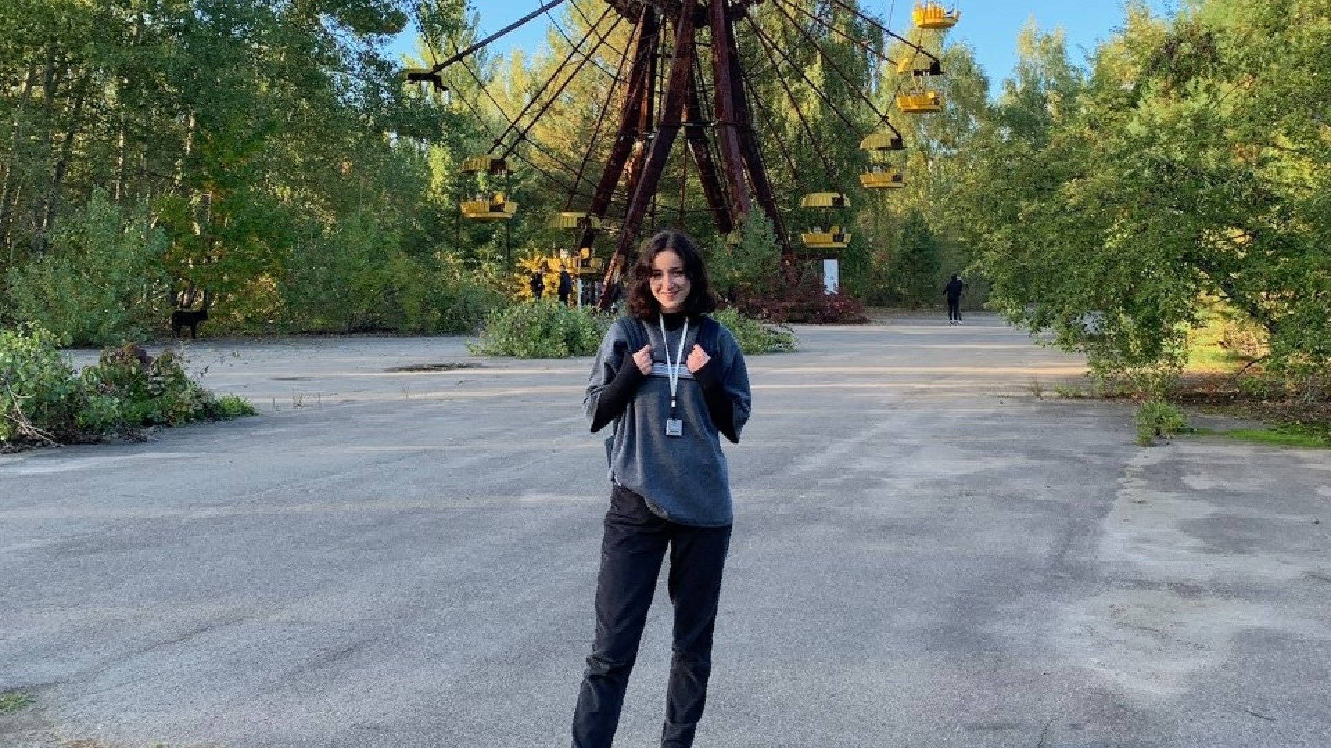 Sophie in Chernobyl with defunct Ferris wheel in the background
