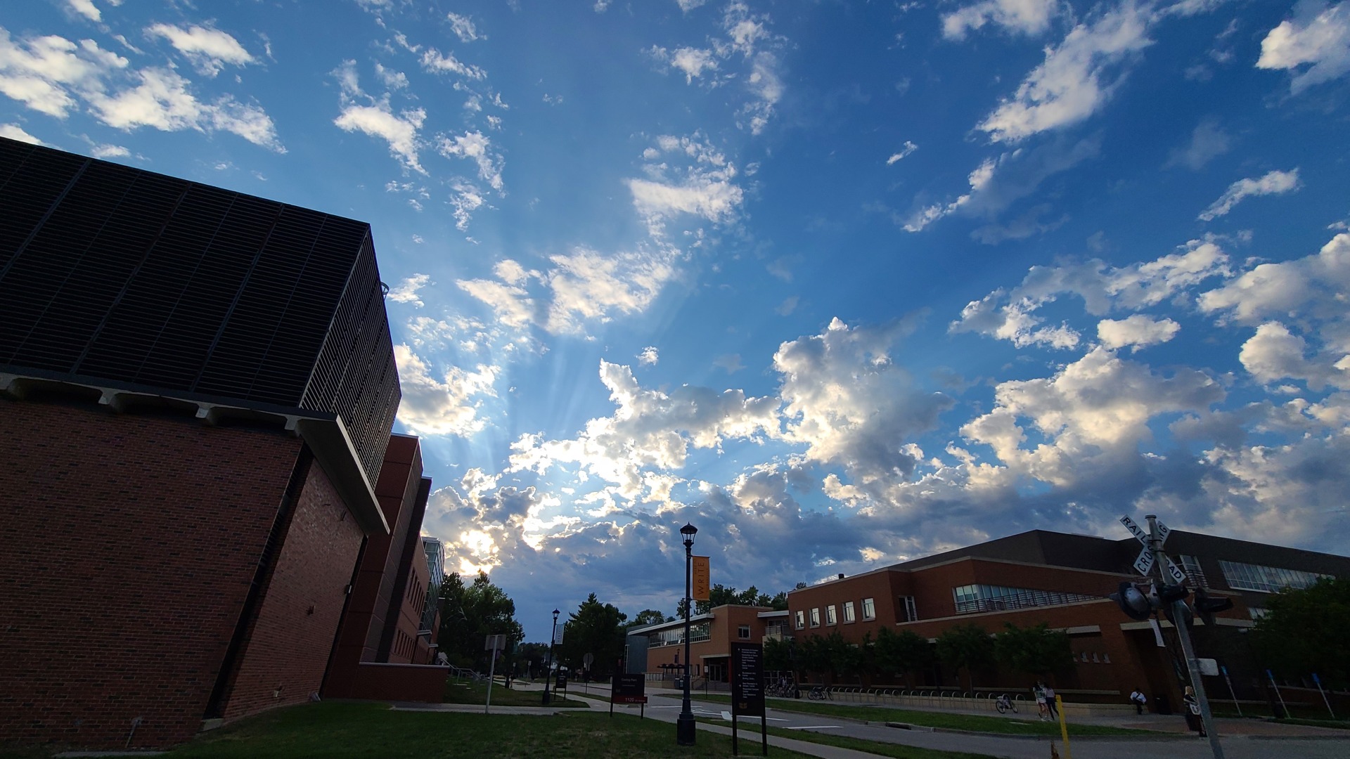 Clouds part the beautiful warm sunlight next to the Noyce science building