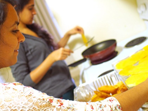 two people cooking together at a stove