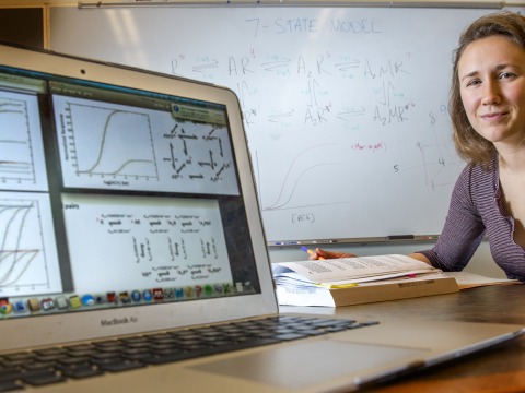Josie Bircher next to computer with models of data