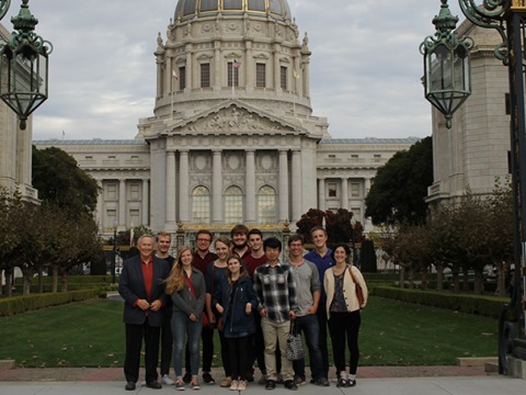 group of Grinnellians standing at a tall cast iron gate with a domed stone building behind them