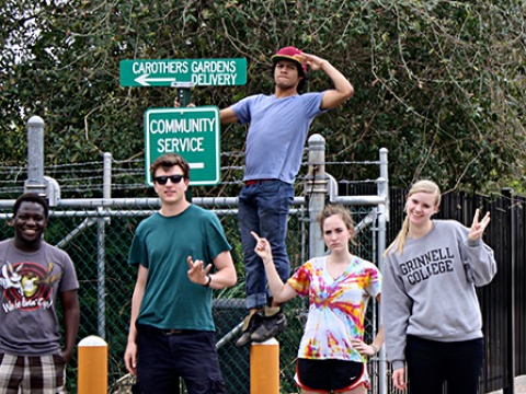 five students stand near street signs reading Carothers garden delivery and Community Service