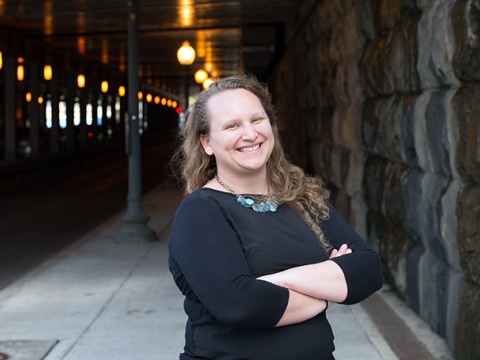 Katie Hail-Jares on stone lined sidewalk at a covered street