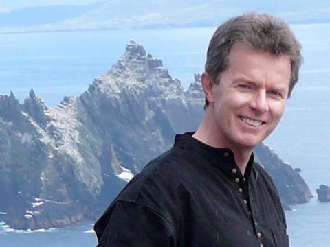 David Schmidtz against backdrop of water and rocky outcrop