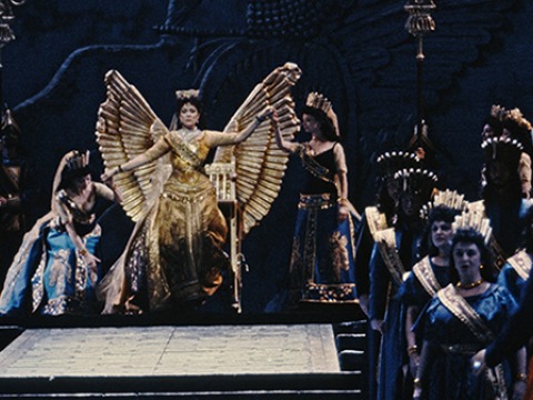 A woman rises from a winged throne.">.<t="