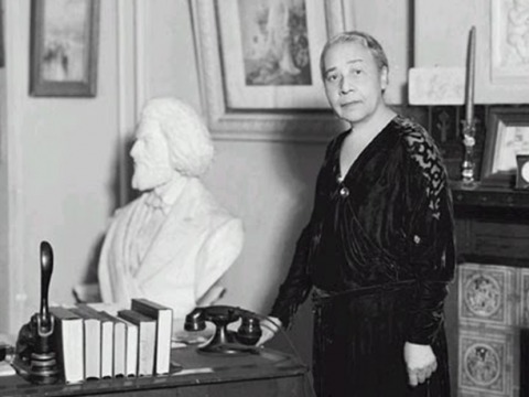 Anna Julia Cooper in a parlor with a bust of Frederick Douglass