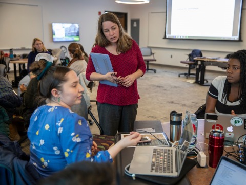 Professor Tammy Nyden (center) listens to two students during class