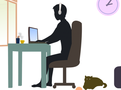 Student sitting at desk w/cat on floor