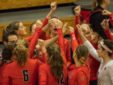 Women's volleyball team huddles together