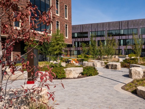 Landscaping in front of HSSC including curving sidewalks, plantings, boulder seating and signage 