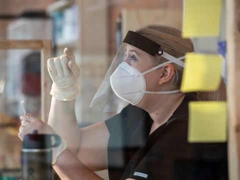 Staff member wearing PPE assisting with COVID testing