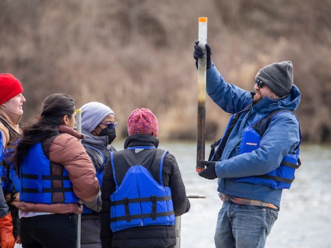 Students and professor examine water sample