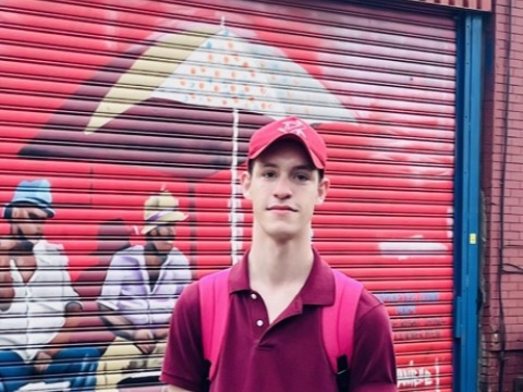 Jack Thornton stands, hands in pockets, in front of a colorful mural