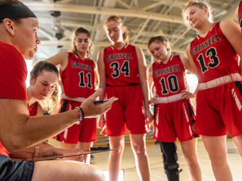Grinnell College women's basketball team in a huddle