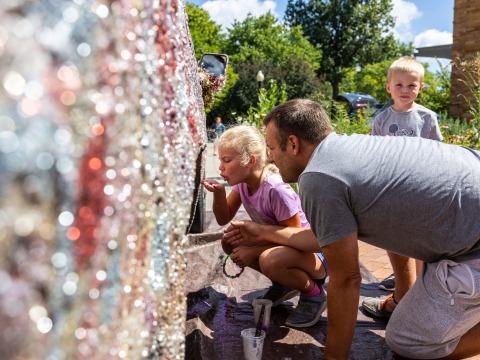 A child and an adult add their artistic touches to the glitter truck.