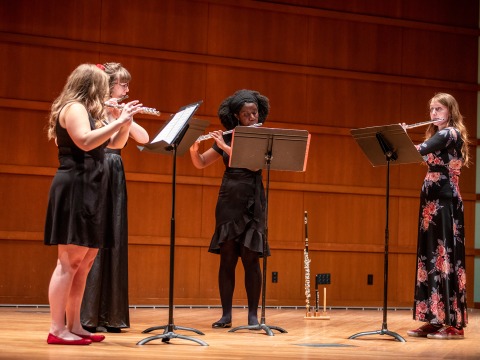 Four flautists perform onstage