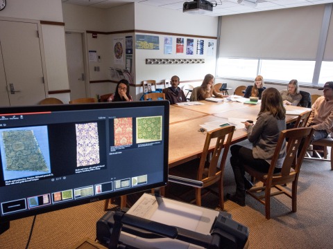 Eiren Shea's classroom, with a screen with textiles on the left corner.