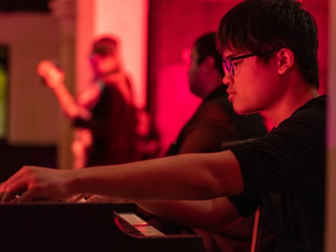 Student playing piano during jazz ensemble concert