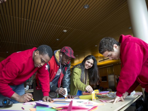 Four students of color make Valentines Day cards