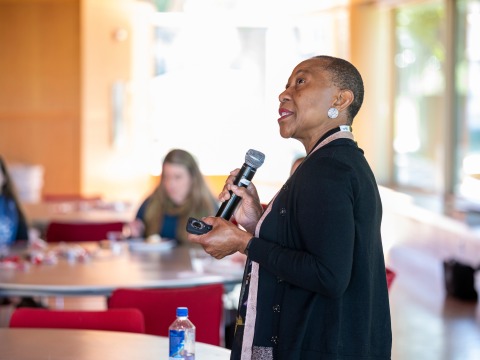 Chinyere Ukabiala speaking to a group with a microphone in hand