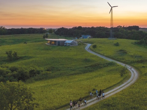 Students follow the road through prairie back to the environmental education center at sunset