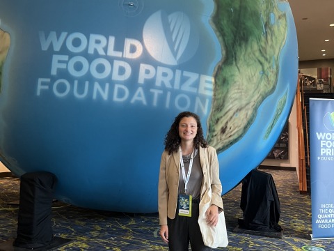 Eleanor Elliott-Rude stands next to a giant globe with the words "World Food Prize Foundation."