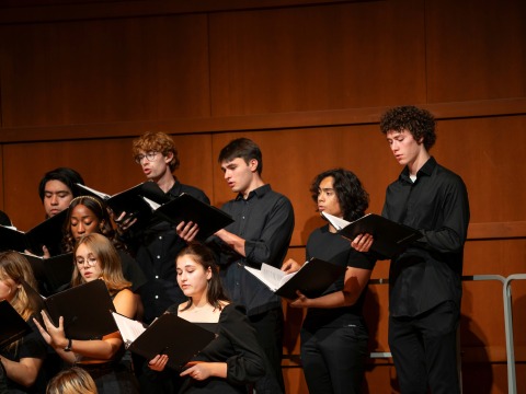 Grinnell Singers Performing on stage wearing all black 