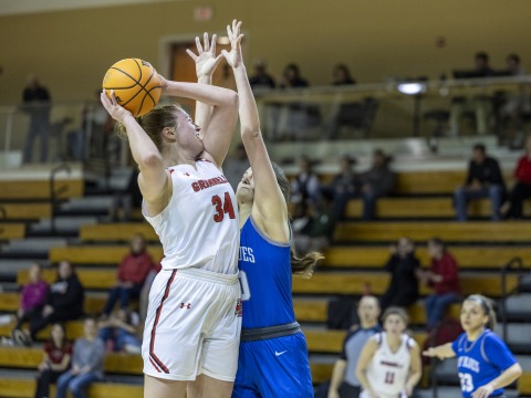 Sara shoots the basketball while an opposing player plays defense