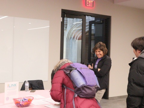 A student signs up at the LINK Mentoring table at the Activities Fair