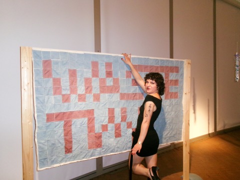   Alina Ihnatesku ’26, with her piece titled “WASTE TIME," which won the Best in Show award at the 2025 Bachelor of Arts Exhibition exhibit at the Grinnell College Museum of Art.  