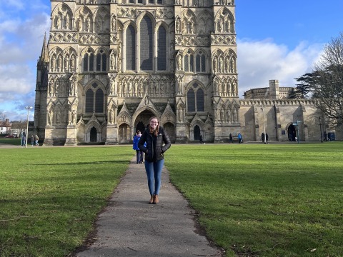 Amy Rinehard stands on the pathway to an ornate cathedral