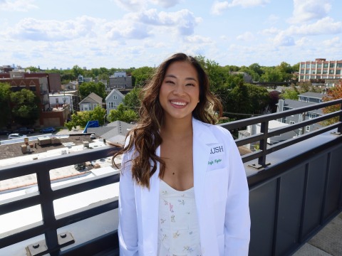 Photo of Kayla Figatner in a white doctor's coat on the roof of a building