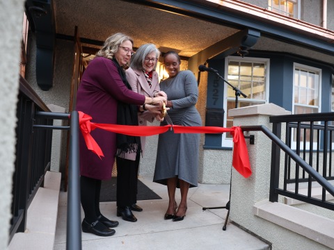 Rachel Bly ’93, left, President Anne F. Harris, and Bernadine Douglas cut the ribbon during the Hannah Alumni House dedication Thursday.