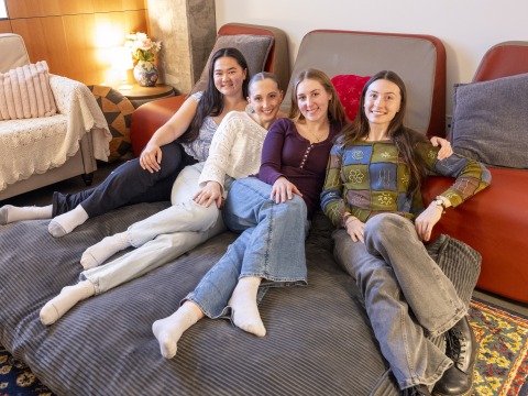 Four smiling young women on a giant beanbag chair