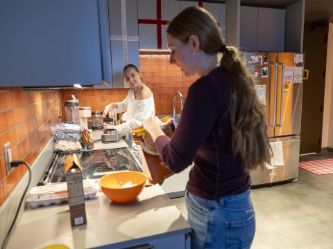 Two young women prepare a meal in a modern kitchen