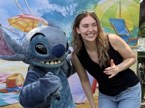 Kylie Snell poses with a mascot of Stitch from the film, Lilo and Stitch.