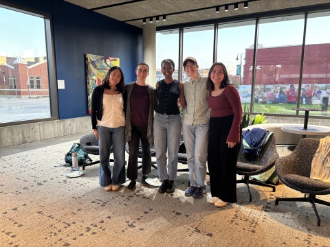 Students standing together in front of chairs in Weingart