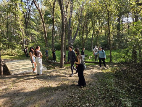 A group of ten people standing in a wooded forest
