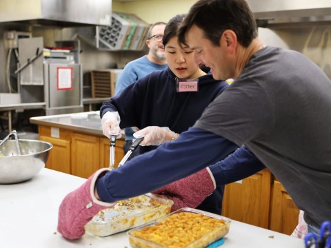 two people preparing a meal in a kitchen
