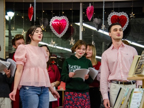 people singing with hearts in the back