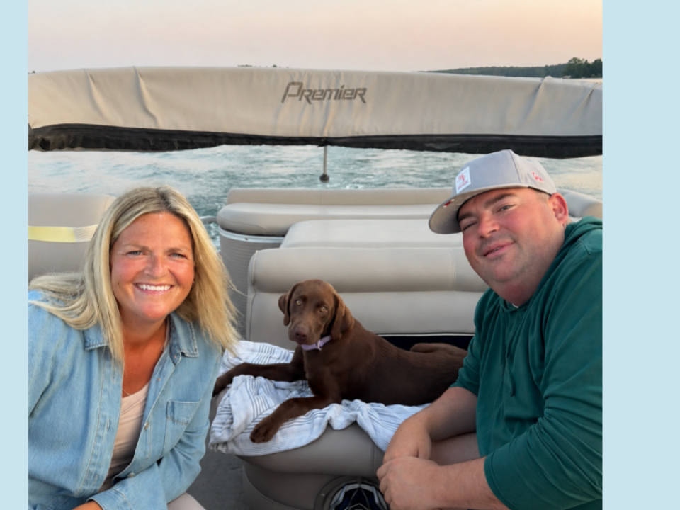 two people and chocolate lab on a boat
