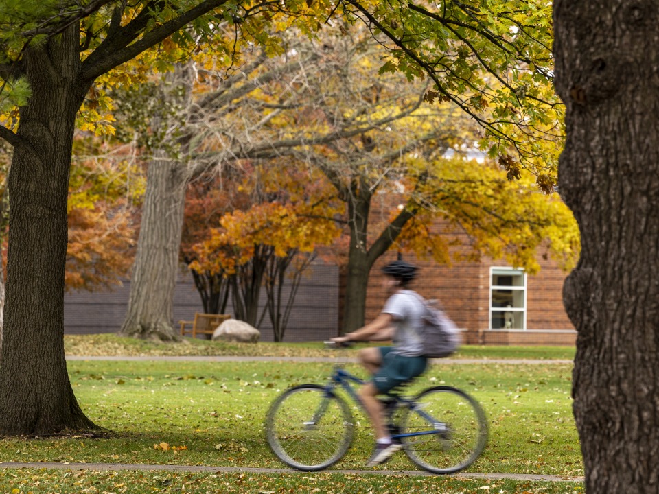 MtC Banner: Student riding bike in spring