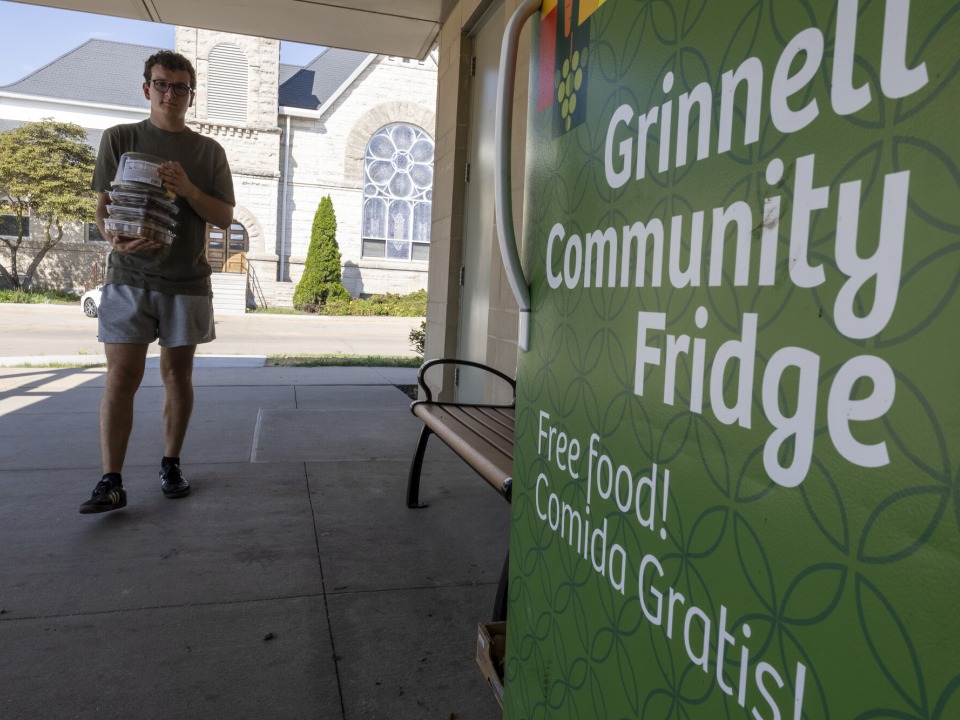 student walking with food in hand to stock fridge