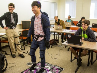 A student plays Dance Dance Revolution in a motion capture suit