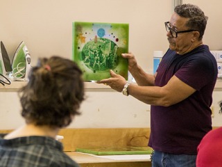 Edouard Duval-Carrie talking and displaying art in front of an audience