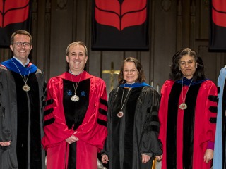 President Kington with designees Shuchi Kapila Daniel Reynolds Elaine Marzluff and Erik Simpson wearing medals They and an unidentified man all wear academic robes