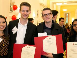 Four students hold certificates at a celebration