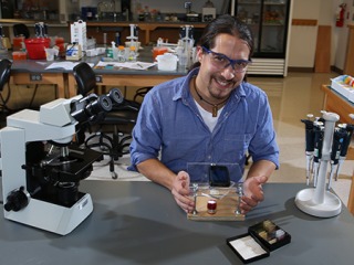 Kenji Yoshino ’11 in a lab with his digital microscope